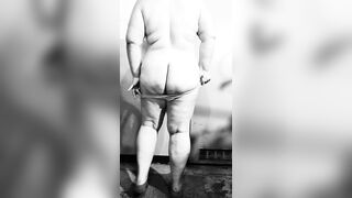 Fat MILF undresses exposed in the basement, showing off her big butt and curvy figure