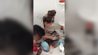 Nice-looking girl gives kitten a bathroom