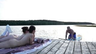 two girls took their raiment off on the lake. A passing surfer had sex in the open air.