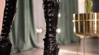 Maid polishes Mistress's latex catsuit