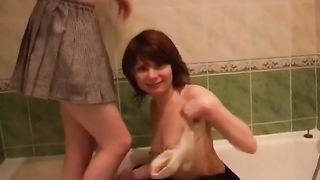 Cute lesbian girlfriends help each other pee in the shower