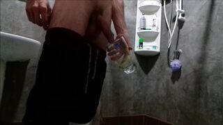 A dude in sweatpants pisses and cums in a glass for his friend, who then drinks it