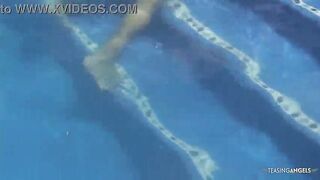 Disinterested lesbian companions are engaging in inappropriate behavior in the outdoor pool while sunbathing.