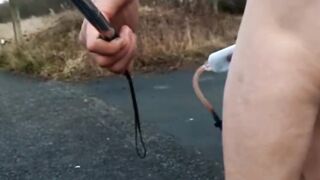 Naked with and without wang pump at side of busy road